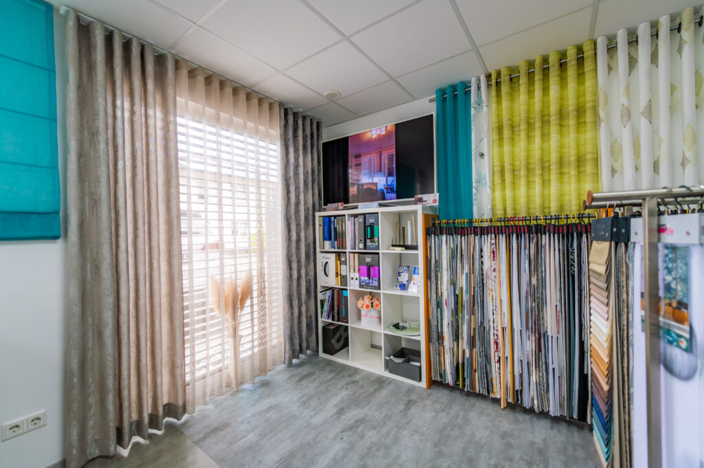 Gardinen- und Stoffauswahl im Beratungsraum von M-Gardindendesign mit verschiedenen Farben, Materialien und Mustern für individuelle Wohnkonzepte.