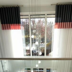 Wohnzimmerfenster mit maßgefertigten Vorhängen und farbigen Akzenten von M-Gardindendesign in Paderborn.