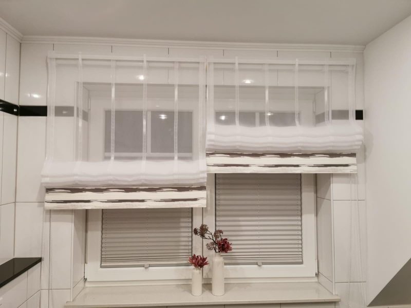 Fenster mit maßgefertigten Raffrollos und dekorativer Fensterbank von M-Gardindendesign.