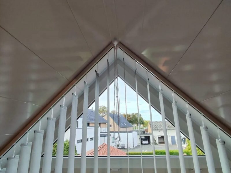 Dreieckiges Giebelfenster mit maßgefertigter Vertikalanlage von M-Gardindendesign in Paderborn.