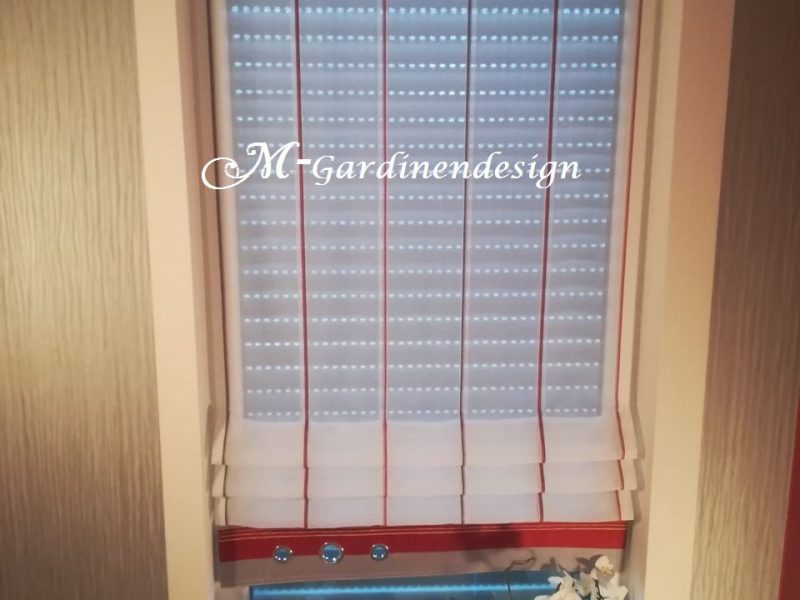 Fenster mit maßgefertigtem Raffrollo und dekorativem Saum von M-Gardindendesign.