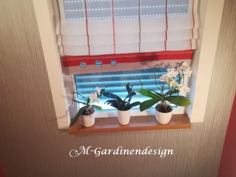 Fenster mit maßgefertigtem Raffrollo und farbigem Saum von M-Gardindendesign.