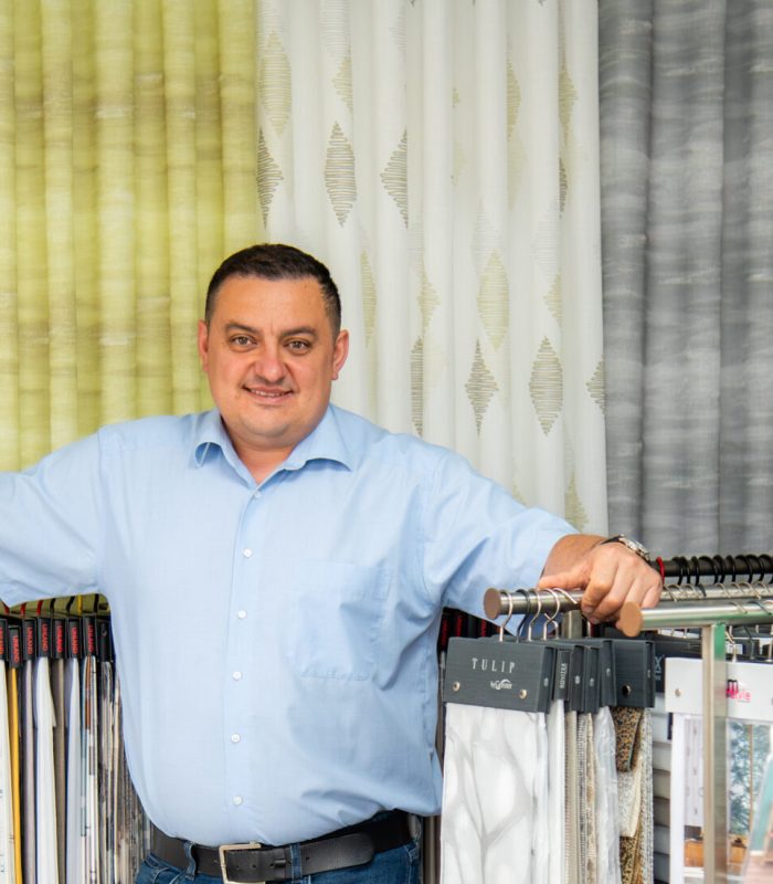 Paul Fahn, Geschäftsführer von M-Gardindendesign, im Showroom mit umfangreicher Stoff- und Gardinenauswahl.