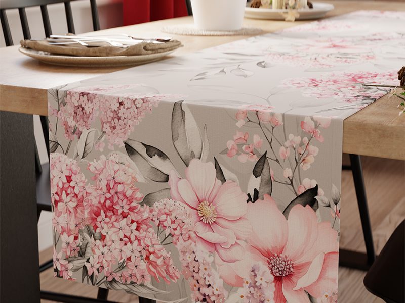Floraler Tischläufer mit großem Blumenmuster von M-Gardindendesign in Paderborn auf Holztisch dekoriert.
