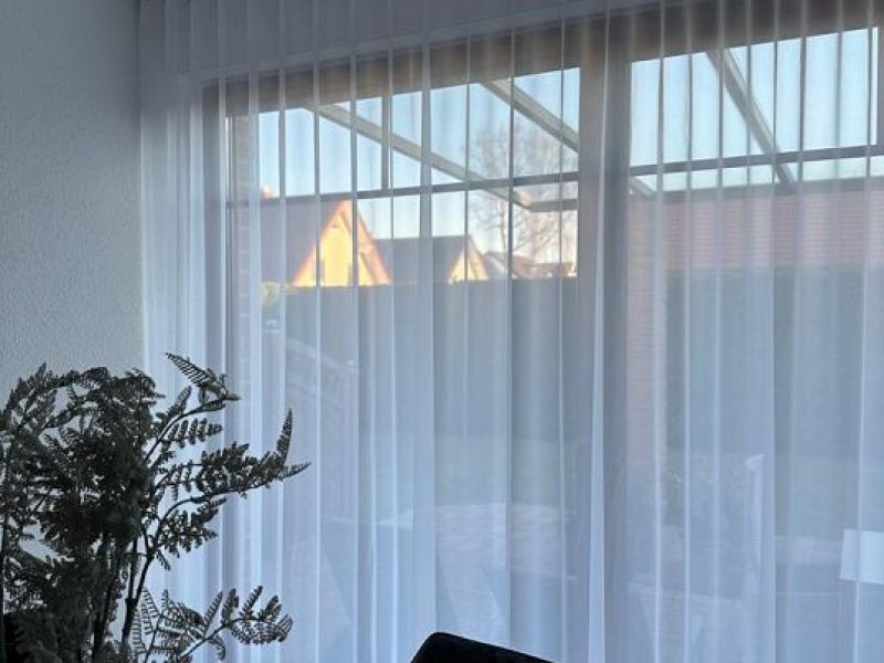 Helles Wohnzimmer mit maßgefertigten, transparenten Gardinen von M-Gardindendesign in Paderborn.