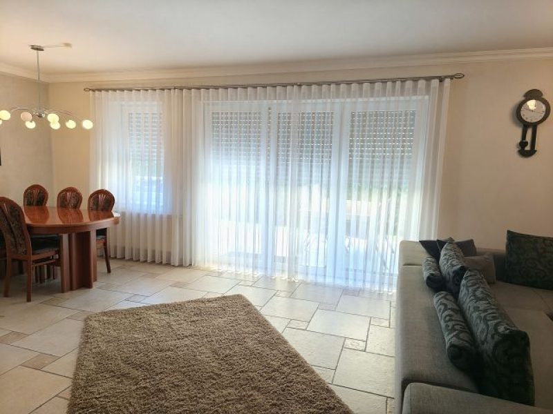 Wohnzimmer mit maßgefertigten, halbtransparenten Gardinen von M-Gardindendesign in Paderborn.