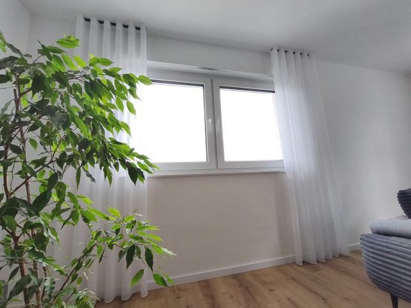 Heller Wohnraum mit Fenster und dezenter Gardinenlösung von M-Gardinendesign